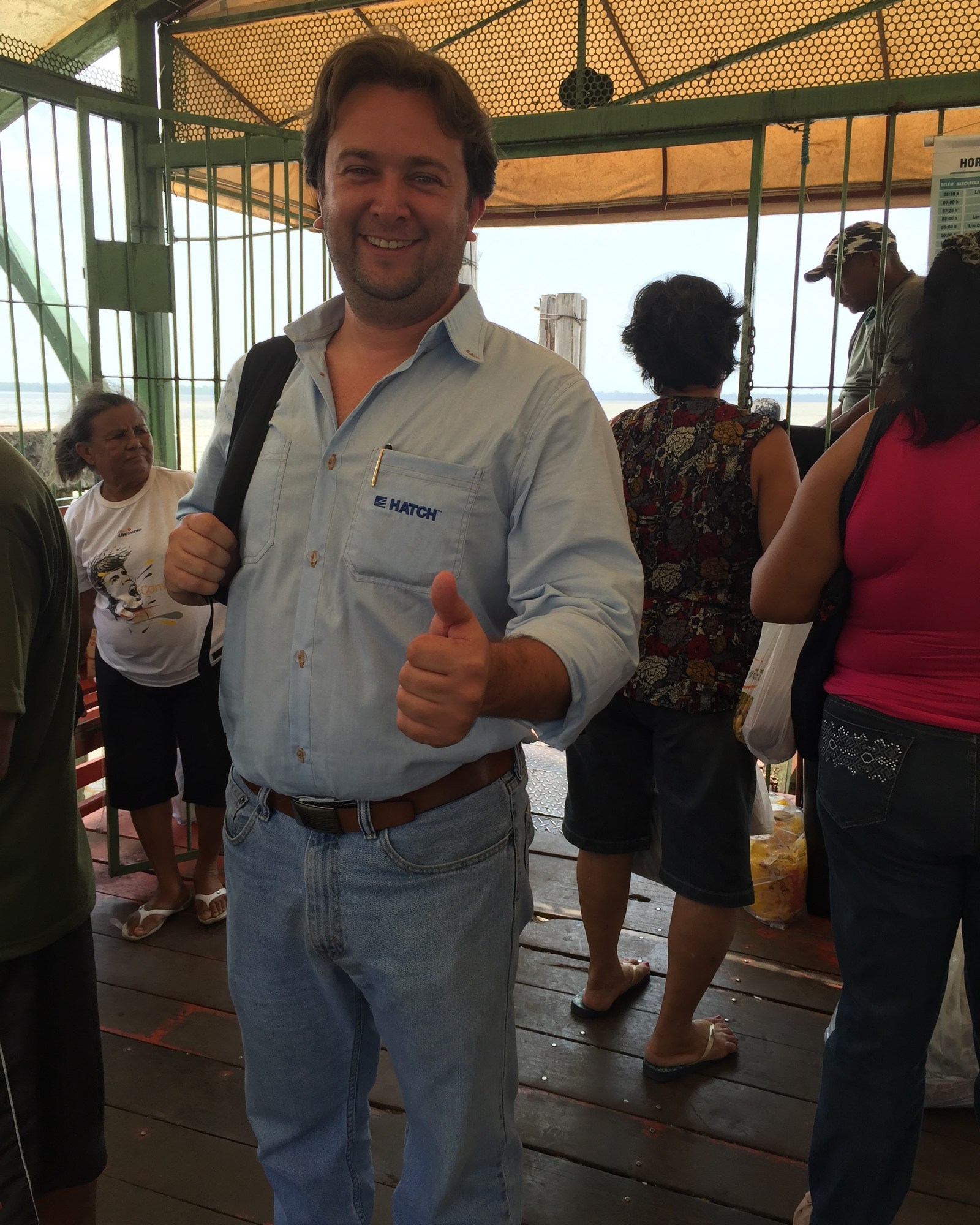Gustavo de camisa da Hatch, em terminal de barcas à beira do rio no Pará